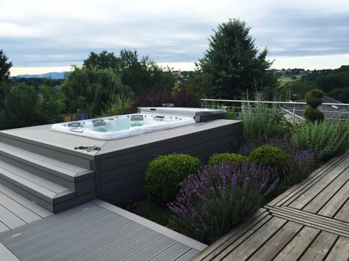 Sundance Spas hot tub installed in the ground in a backyard space.