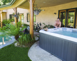 Woman soaking in her outdoor hot tub and talking to her husband.